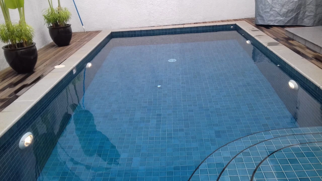 Kolam renang privat skimmer box dengan tangga sudut melengkung di Jakarta